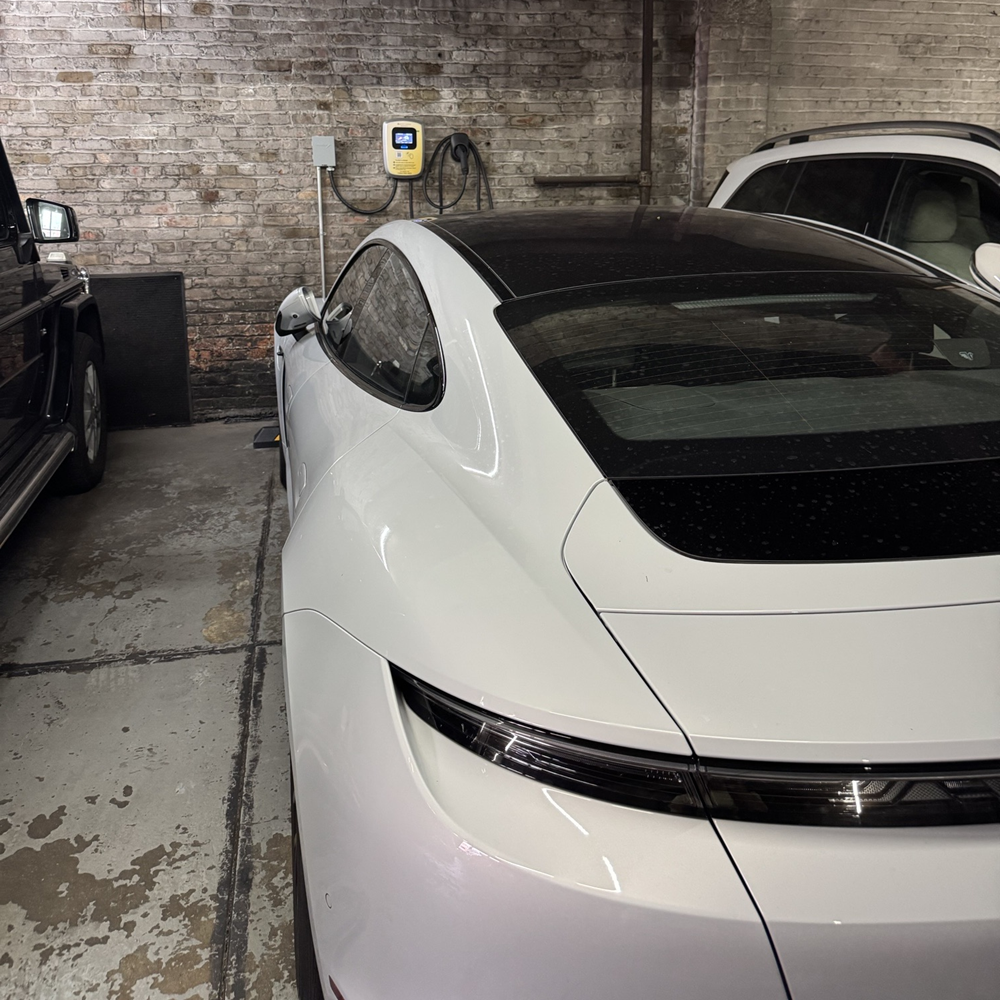 Expert technician installing reliable EV charging station in busy New York parking lot americharge